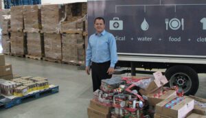 A man standing in front of boxes and other items.