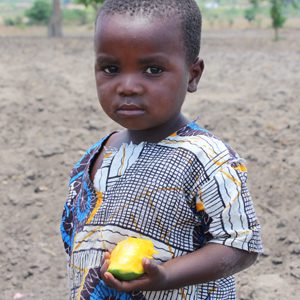 A young boy holding an apple in his hand.
