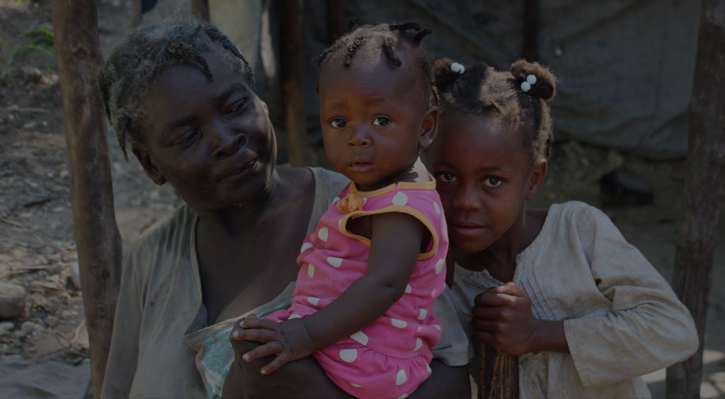 A woman and two children are standing together.