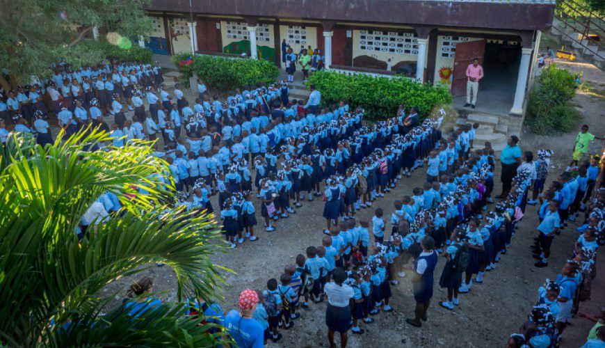 A group of people standing in the middle of an outdoor area.